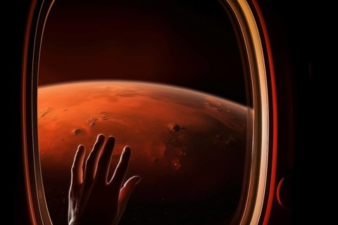 Mars landscape seen through spaceship window illuminator with astronaut hand touching the glass.