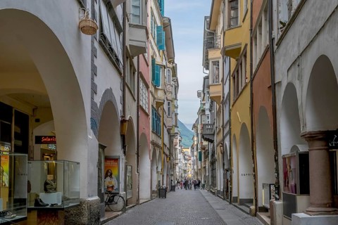 View through a lively pedestrian zone with arcades and shops, historic arcade in the old town