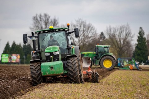 Tractor with a power harrow prepares the soil of a field for planting, Agriculture, Spring
