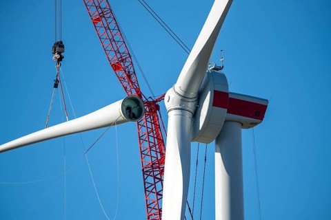 Assembly of a wind turbine, the last rotor blade is being mounted, mobile crane, wind turbine from