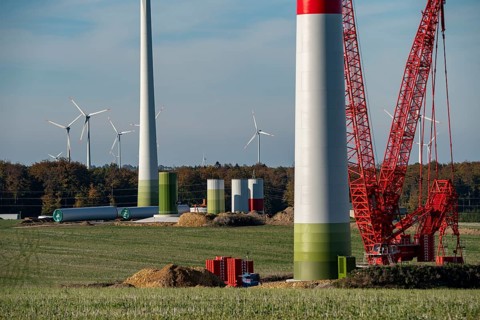 Assembly of a wind turbine, the last rotor blade is being mounted, mobile crane, wind turbine from