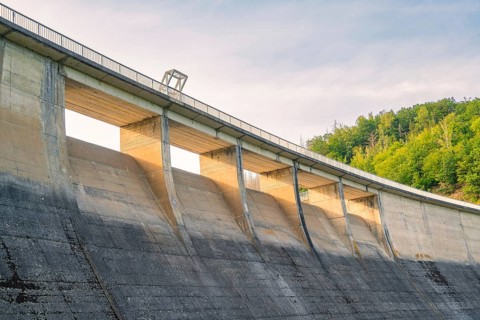A large concrete dam rising against the sky, surrounded by green nature, Rappbodetalsperre, Harz