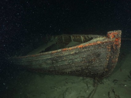 A shipwreck of a rowing boat lies on the sandy lake bottom, dive site Schoggiwand, Lake Zurich,