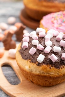 Homemade glazed and decorated easter pies with chocolate eggs and rabbits on a gray wooden
