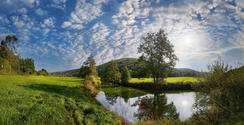 Panoramic landscape at the river Vils with wide meadow, trees and bright sky, Emhof, Kallmünz,