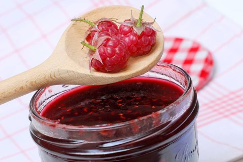 Raspberries (Rubus idaeus) on raspberry jam, raspberry jam, wooden spoon