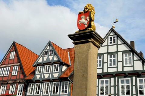 Lion sculpture with coat of arms of Lower Saxony, half-timbered houses, Celle, Lower Saxony,