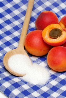 Apricots ( Prunus armeniaca) , Cooking spoon with sugar