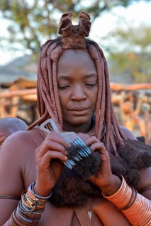 Himba woman combing her hair, Omuramba, Kaokoland, Kunene, Namibia, Africa