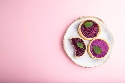 Sweet tartlets with jelly and milk cream on a pastel pink background. top view, flat lay, copy