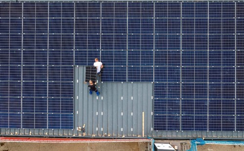 Installation of solar modules on the roof of a barn on a farm, over 210 photovoltaic modules are