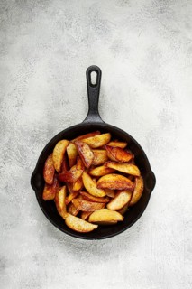 Fried potato slices, in a cast-iron pan, homemade, no people