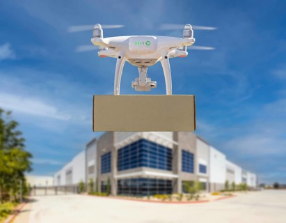Unmanned aircraft system (UAS) quadcopter drone carrying blank package near corporate commercial