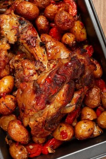 Pork knuckle, baked with vegetables, new potatoes, on a baking sheet, homemade, no people