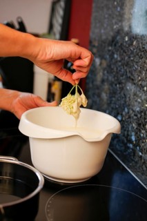 Swabian cuisine, preparation of elderberry cakes, Hollerkiacherl, dipping elderflowers in dough,