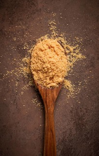 Wooden spoon with hazelnut flour, top view, no people, on a table