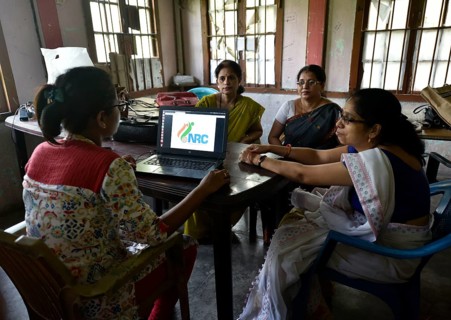 Officials checks the documents submitted by people at an National Register of Citizens (NRC) Seva