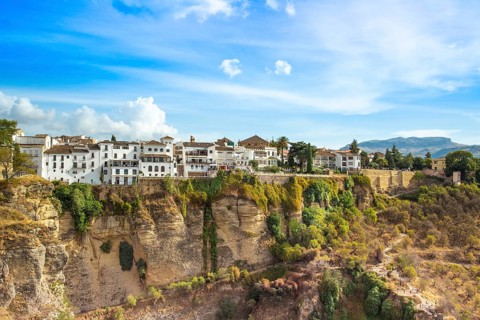 Famous Ronda restaurants and colonial houses overlooking the scenic gorge and the Puente Nuevo