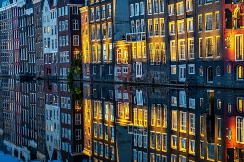 Canal houses on the Damrak, in the centre of the old town of Amsterdam, harbour, starting point of