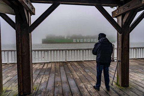 Thick fog in winter, hanging over the mouth of the Elbe into the North Sea, container ship Ever