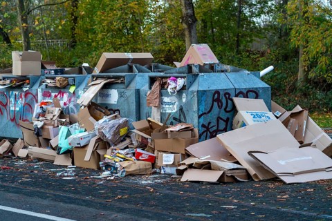 Overfilled waste paper containers, despite the overcrowding, people have put their waste paper next