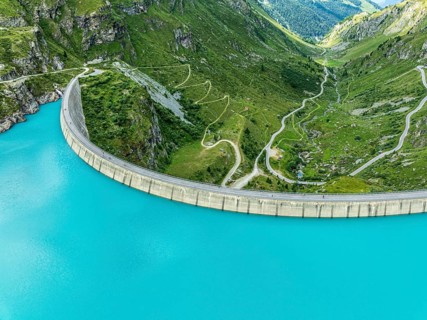 Dam of the Moiry lake, Lac de Moiry, turquoise glacial water, winding mountain road, aerial view,
