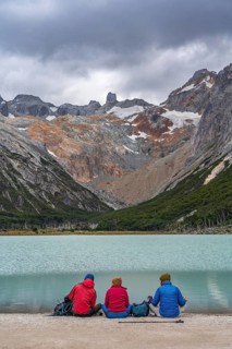 Hikers sitting on the shore of the glacial lake Laguna Esmeralda, Tierra del Fuego Island,