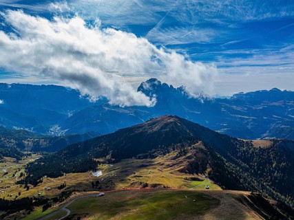 The Picberg, behind it the peaks of the Sassolungo Group, shrouded in mist, drone shot, Val