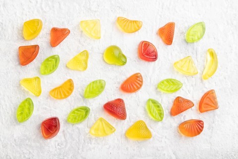 Various fruit jelly candies on gray concrete background. top view, flat lay, close up