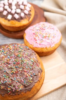 Homemade glazed and decorated easter pies with chocolate eggs and rabbits on a gray wooden