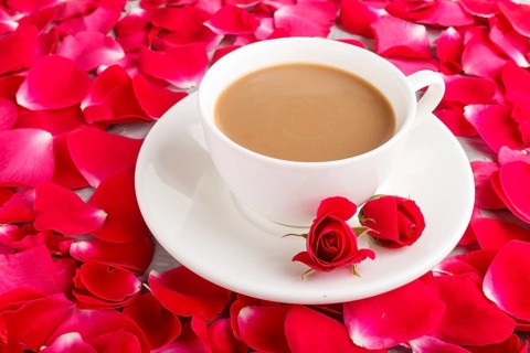 Red rose petals background and a cup of coffee. Morninig, spring, fashion composition. side view,