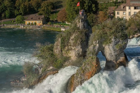 Rhine Falls seen from Laufen Castle, rocky island, Swiss flag, spray, watermill, Canton Zurich, on