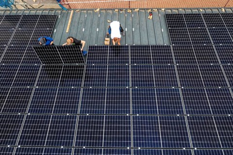 Installation of solar modules on the roof of a barn on a farm, over 210 photovoltaic modules are