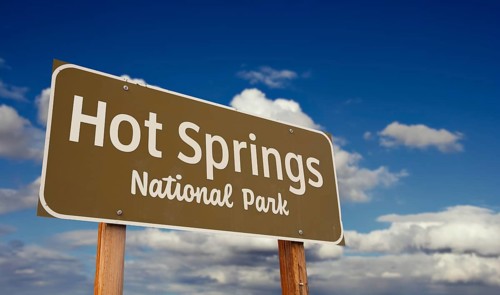Hot springs national park (arkansas) road sign against blue sky and clouds