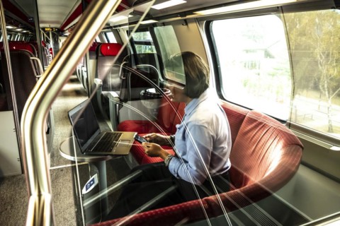 Business Woman Working on Laptop and Smartphone in First Class in a Train in Switzerland