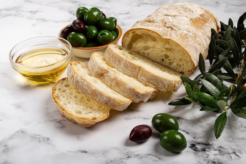 Appetizer, sliced ciabatta bread, with olive oil, green olives, Chalkidiki olives, classic Green