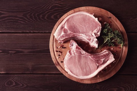 Fresh, raw pork meat, sliced, on a cutting board, with spices, horizontal, rustic style, toning, no