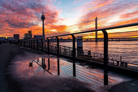 Winter sunset on the Rhine near Düsseldorf, riverside promenade at the old town, Rhine Tower, cargo