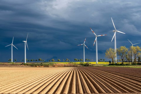 Wind turbines on a rape field, dark rain clouds, in the Rhenish lignite mining area, near