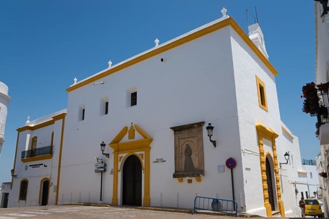 White church with yellow details, under a blue sky, in Mediterranean architectural style, Iglesia