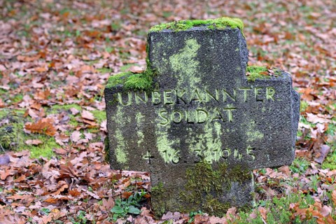 Military cemetery from the Second World War, moss-covered stone cross with inscription, Moselle,