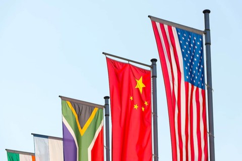 Various national flags fly on flagpoles against a blue sky, Chinese flag, American flag