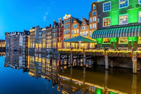 Canal houses on the Damrak, in the centre of the old town of Amsterdam, harbour, starting point of