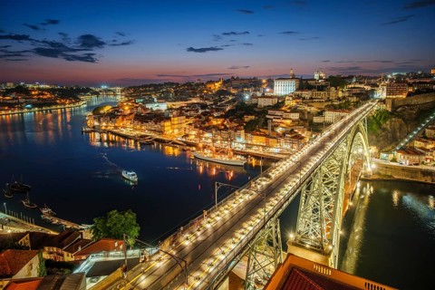 View of illuminated Porto city and Douro river and Dom Luis bridge I from famous tourist viewpoint