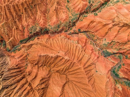Eroded mountain landscape, top-down, canyon with red and orange rock formations, aerial view,