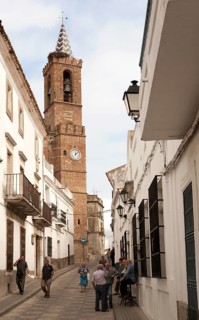Church of Our Lady of the Assumption and people in village street, Aroche, Sierra de Aracena,