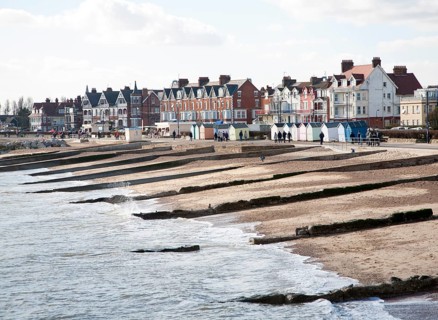 Sandy beach concrete groyne sea defences and historic buildings on the seafront on a sunny day in