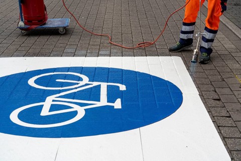 Application of road markings for a cycle lane, Rüttenscheider Straße in Essen, in the shopping and