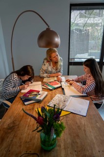 Homeschooling, during the lockdown in January 2021, mother helps her two daughters, at home,
