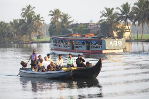 Indian men travelling on a motorboat, canal system of the backwaters, Kerala, India, Asia